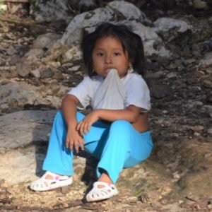 Small girl sitting on stone